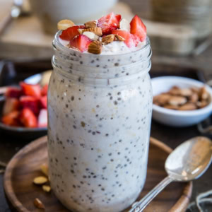 jar of strawberry overnight oats with chopped nuts and fresh strawberries sprinkled on top.