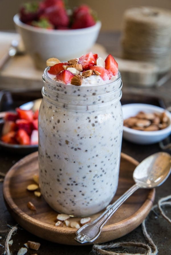 jar of strawberry overnight oats with chopped nuts and fresh strawberries sprinkled on top.