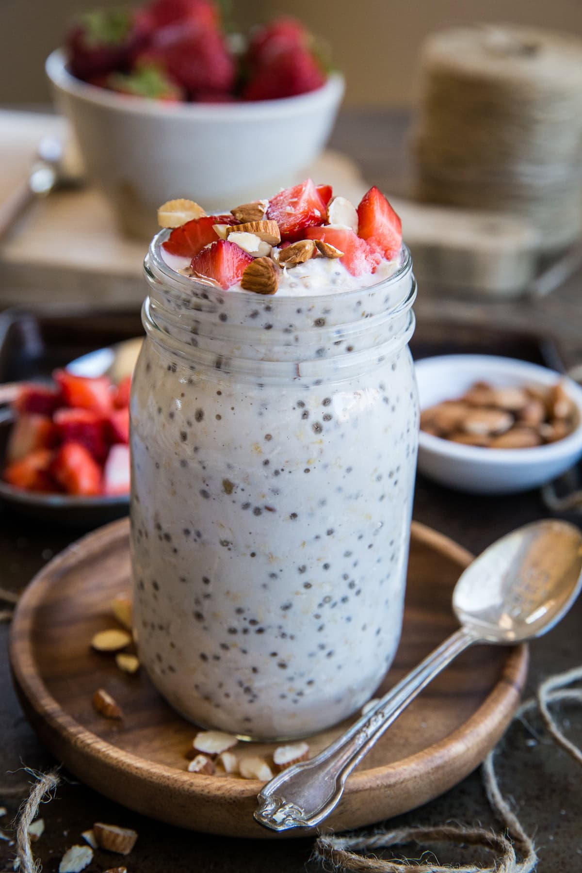 jar of strawberry overnight oats with chopped nuts and fresh strawberries sprinkled on top.