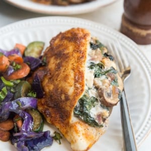 Mushroom and Spinach Stuffed Chicken Breast with roasted vegetables for a healthy weeknight dinner.