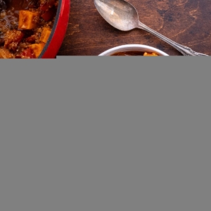 Sweet Potato black bean quinoa chili in two bowls with topping. A spoon and napkin to the side, ready to serve.