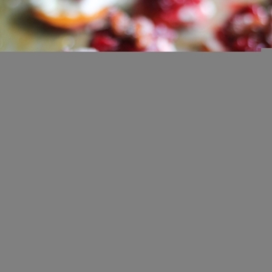 Sweet Potato Rounds with Goat Cheese, Roasted Cranberries on a baking sheet, drizzled with honey fresh out of the oven.