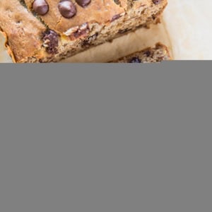 Loaf of gluten-free banana bread on a sheet of parchment paper, cut into slices.