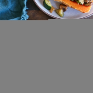 Two halves of butternut squash on two plates, stuffed with ground turkey, kale, mushrooms, zucchini, and more. Ready to serve.