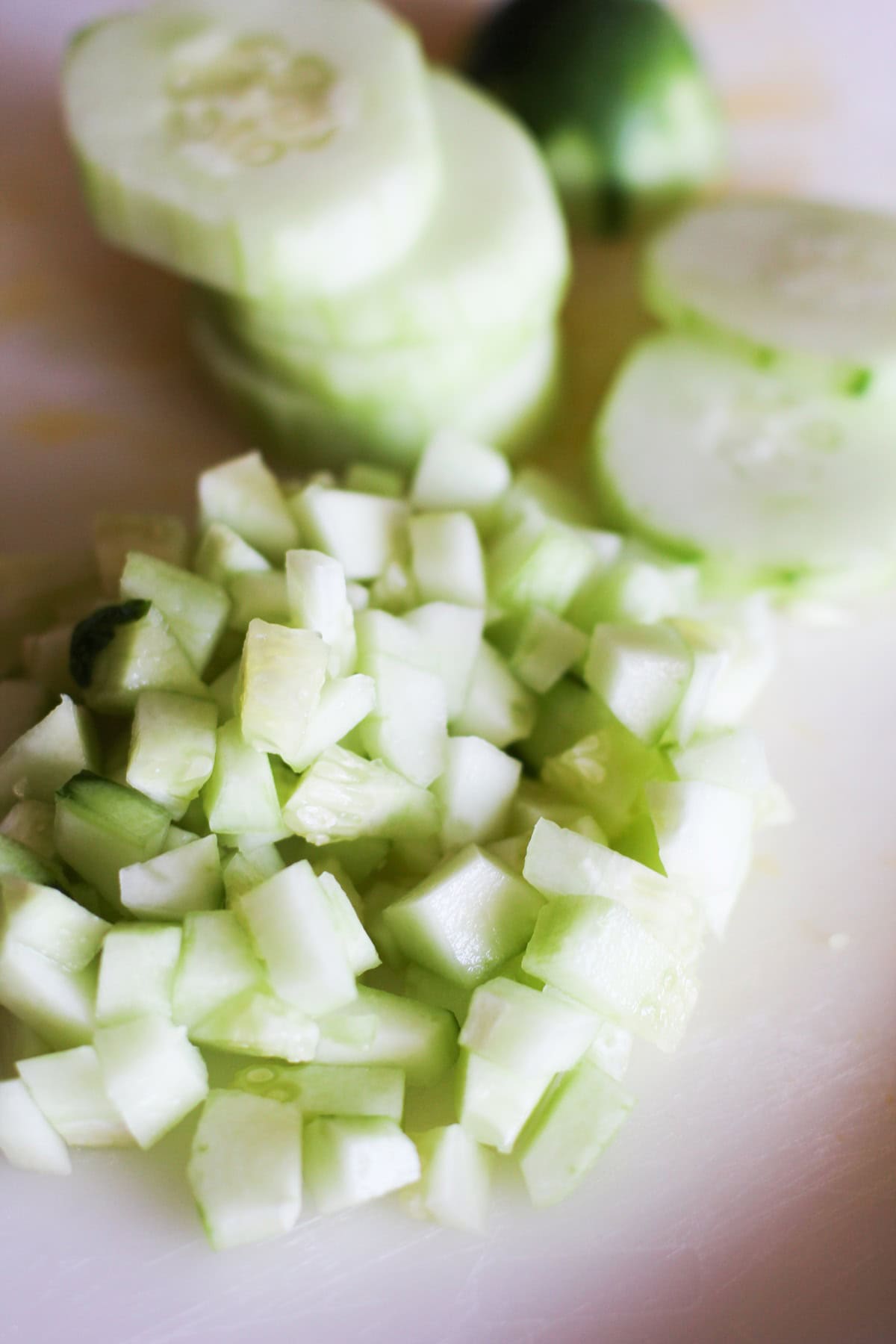 Chopped cucumber on a cutting board.