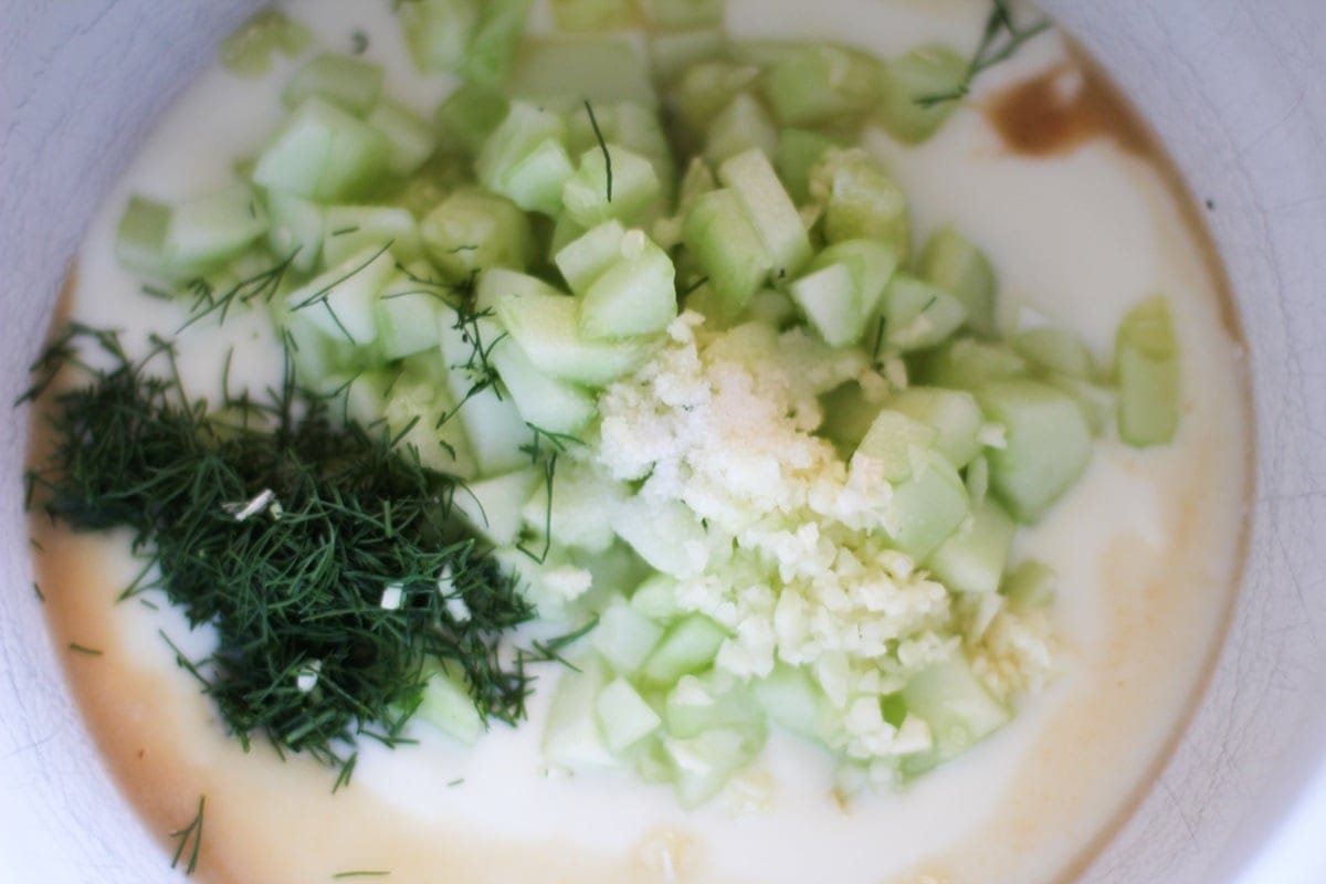 Ingredients for tzatziki sauce in a mixing bowl.
