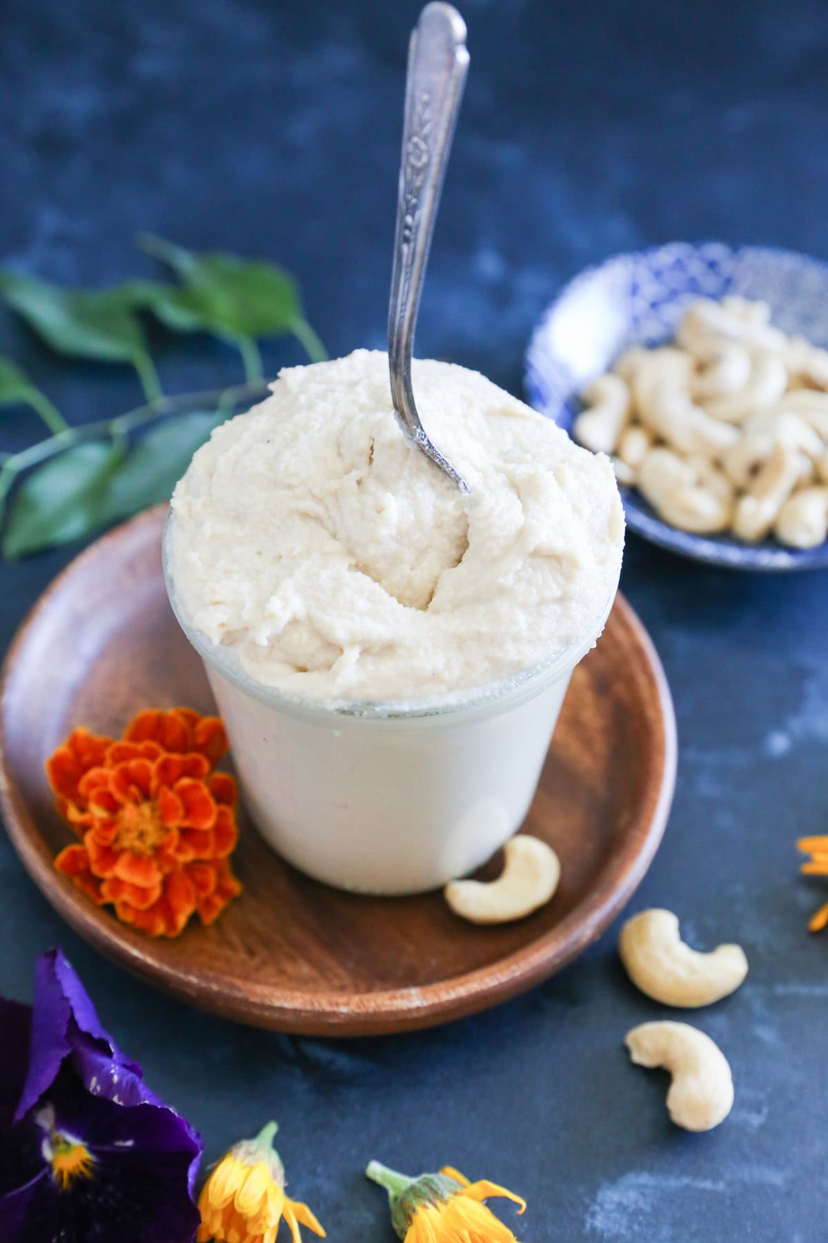 Homemade dairy-free cream cheese frosting in a jar with a spoon sticking out, ready to use.