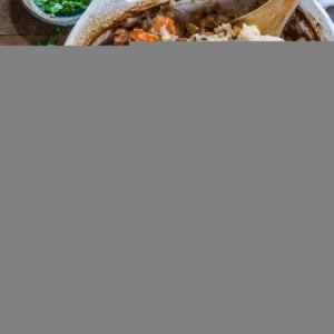 casserole dish of wild rice chicken casserole on rustic backdrop with two plates to the side