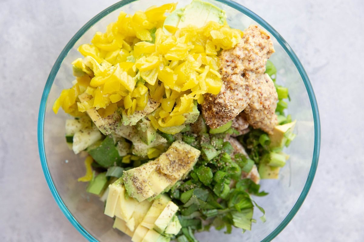 Ingredients for salmon salad in a mixing bowl, ready to be stirred together.