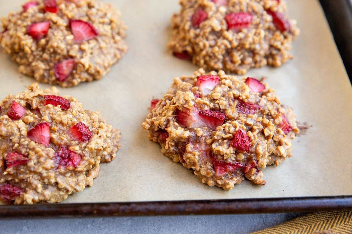 Freshly baked strawberry oatmeal cookies on a cookie sheet fresh out of the oven.