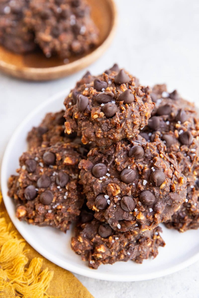White plate with a stack of no-bake cookies on top and a golden napkin to the side.