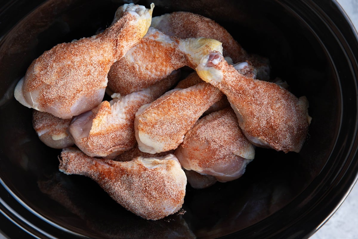 Drumsticks seasoned with dry rub in a slow cooker.