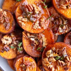 Plate stacked with melting potatoes with pecans and maple, ready to serve.