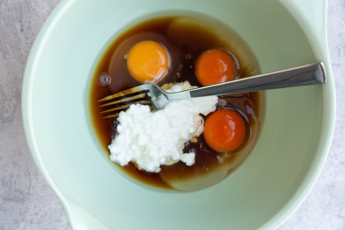 Cottage cheese, eggs, and pure maple syrup in a mixing bowl.