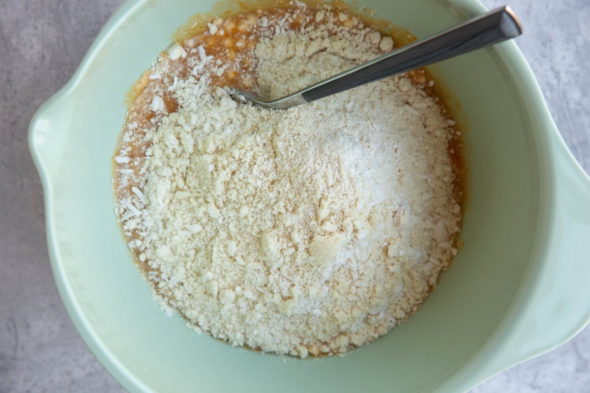 Mixing bowl with wet ingredients on the bottom, and dry ingredients on top, ready to be mixed in.