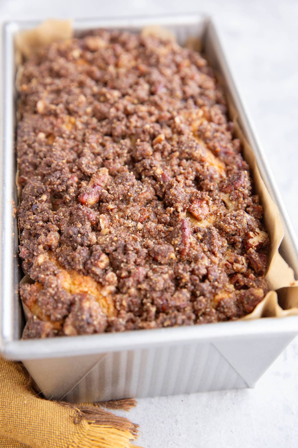 Loaf of cinnamon roll bread in a loaf pan fresh out of the oven.