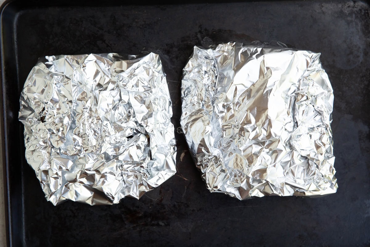 Baking sheet with two large foil packets.