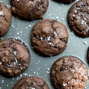 Almond Flour Chocolate Zucchini Muffins in a muffin tray, sprinkled with sea salt.