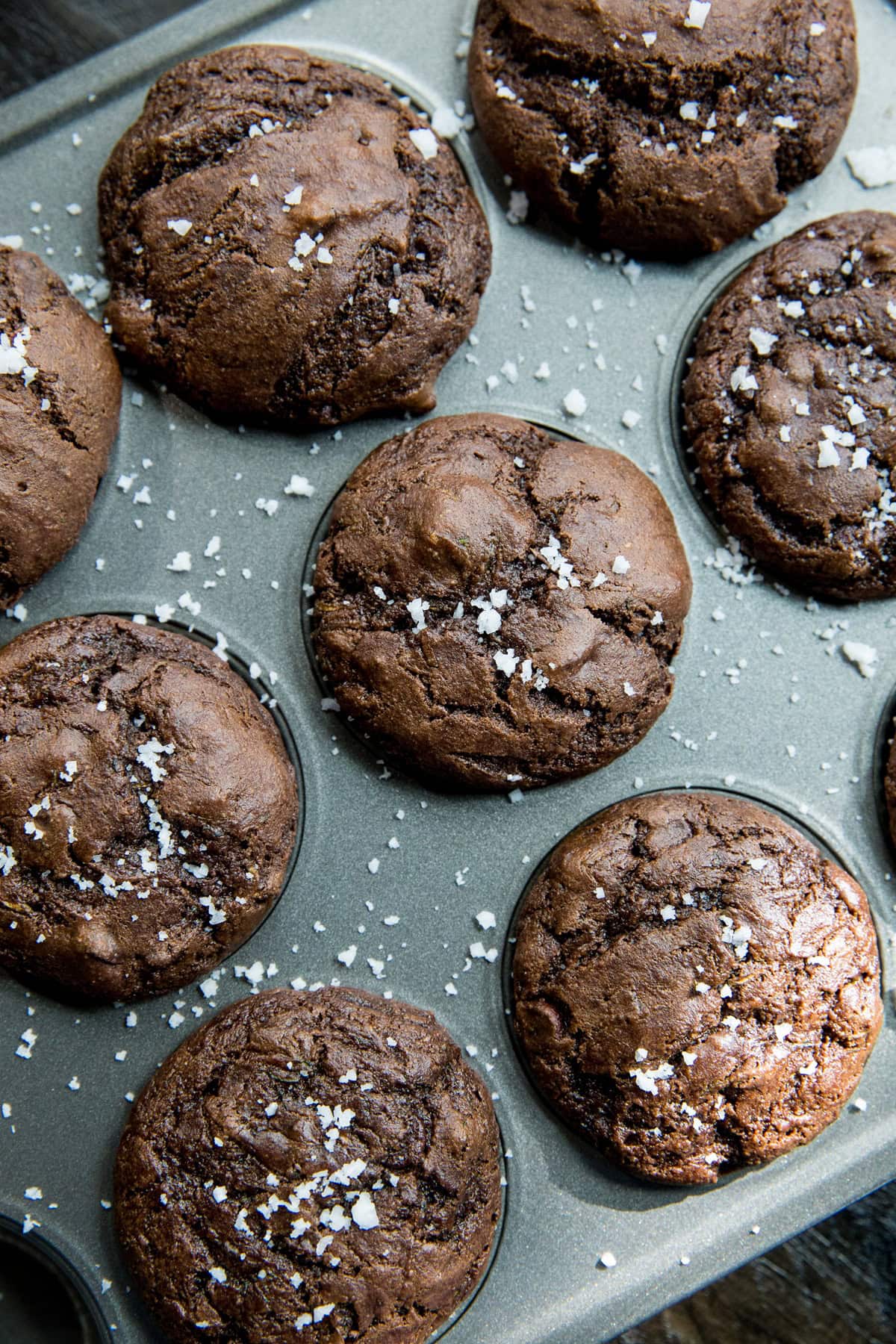 Almond Flour Chocolate Zucchini Muffins in a muffin tray, sprinkled with sea salt.