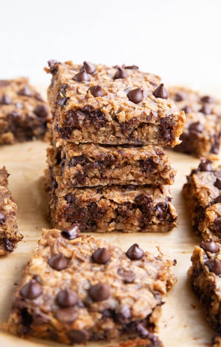 Stack of oatmeal protein bars with many bars all around.