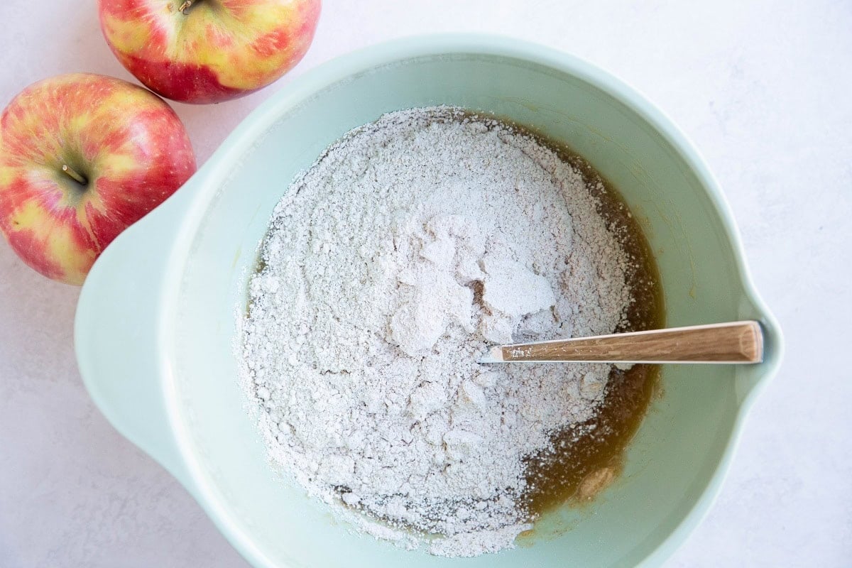 Mixing bowl with wet ingredients on the bottom and dry ingredients on top, ready to be mixed together.