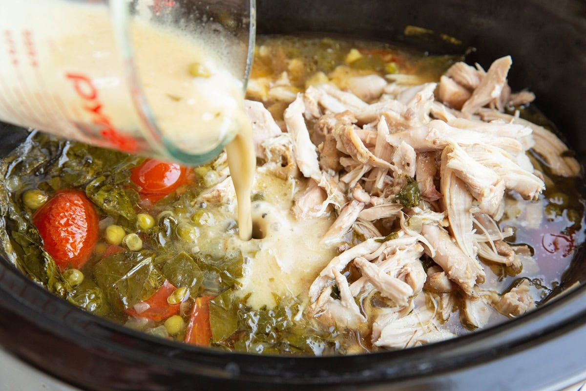 Pouring broth mixed with flour into the crock pot to thicken the stew.