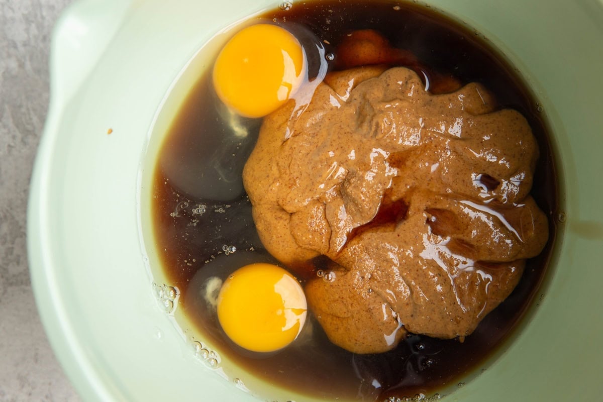 Mixing bowl with almond butter, pure maple syrup, and eggs.
