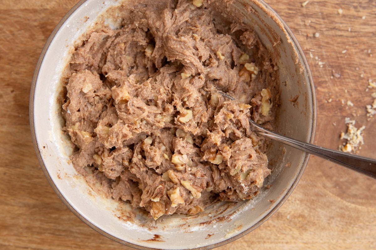 Cobbler topping mixture in a medium sized bowl all mixed up with a spoon.