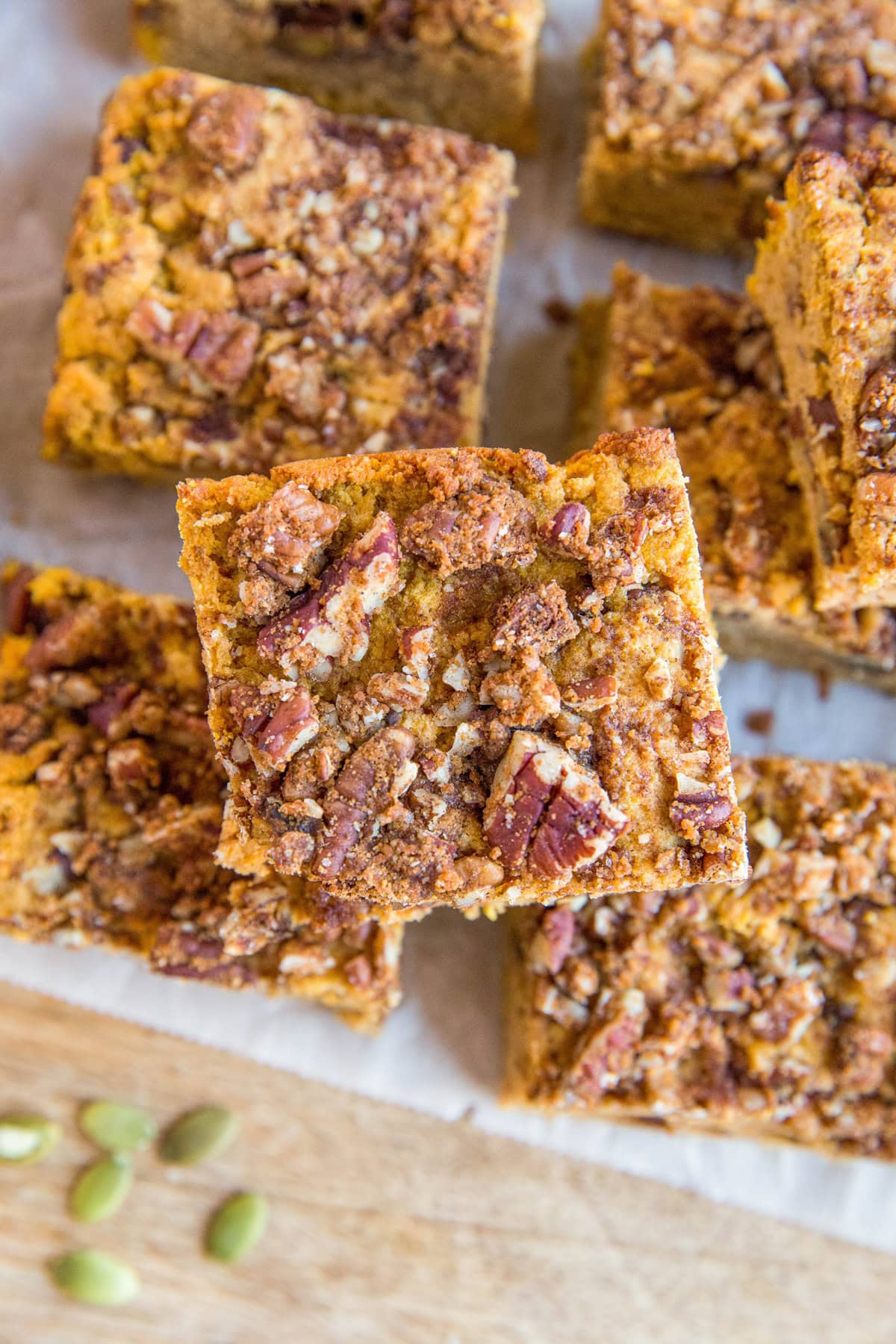 Slices of coffee cake on parchment paper on a wooden cutting board, looking down.