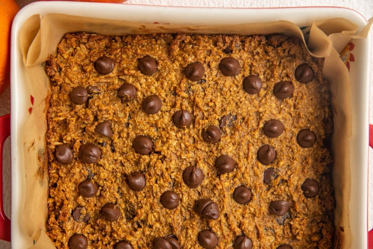 Baking dish with sweet potato oatmeal bars inside, topped with chocolate chips.