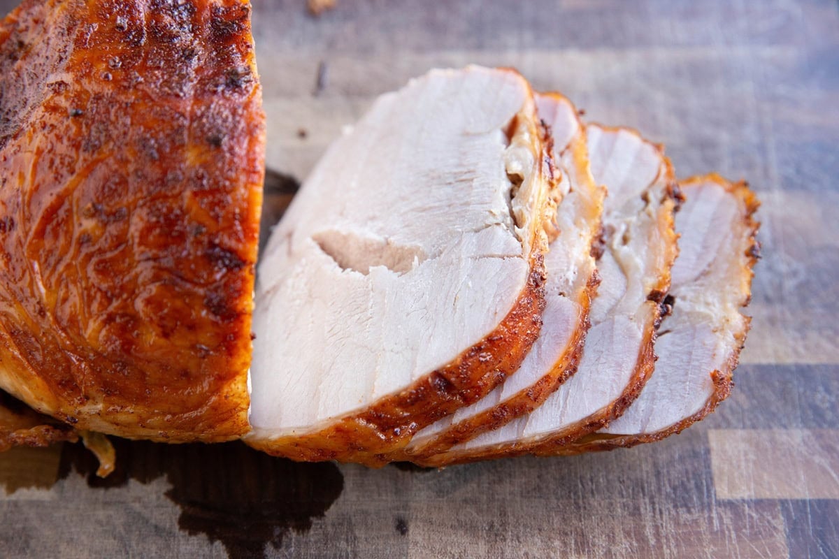 Turkey roast on a cutting board, cut into slices.