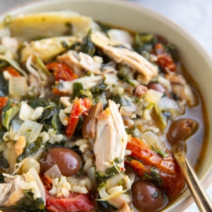 Mediterranean Chicken Soup in a bowl with a golden spoon.