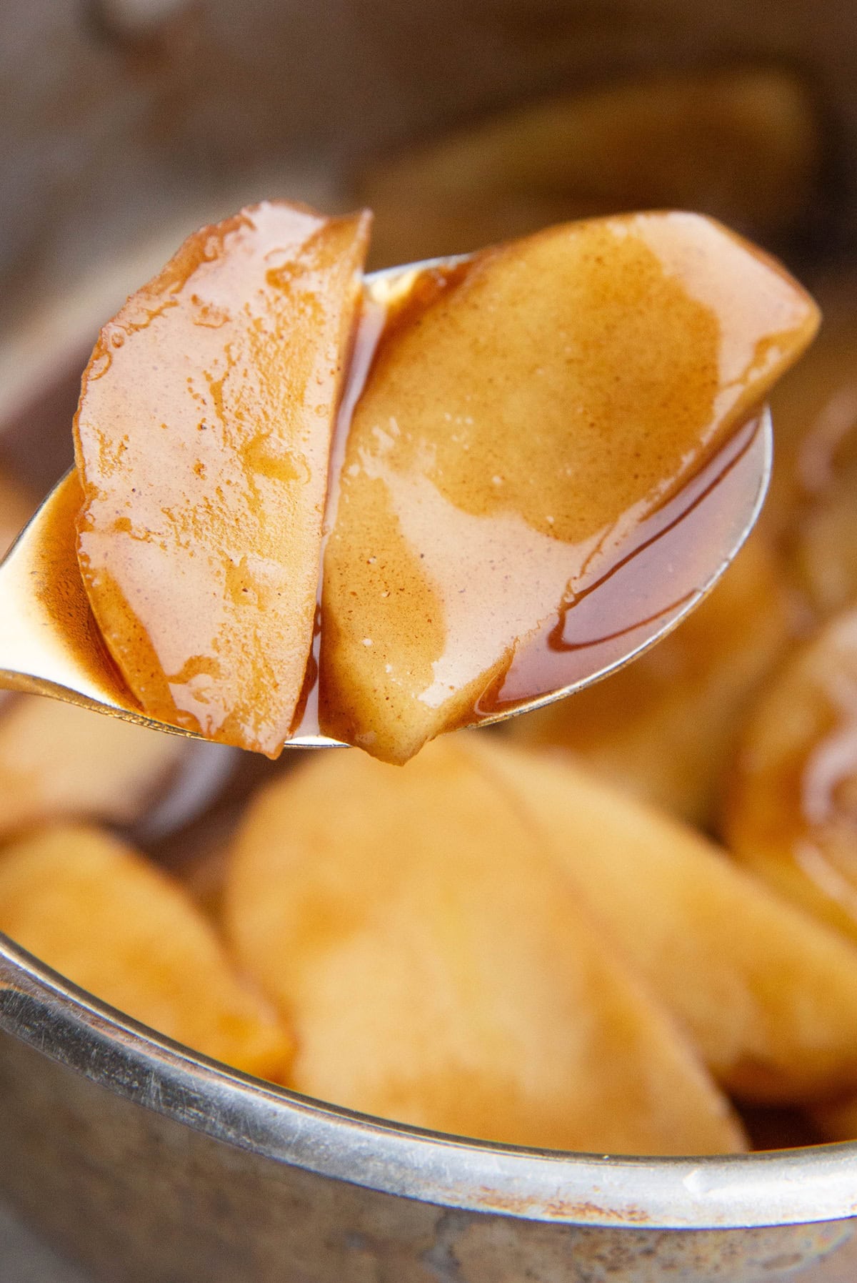 Close up shot of two stewed apples surrounded in sauce.
