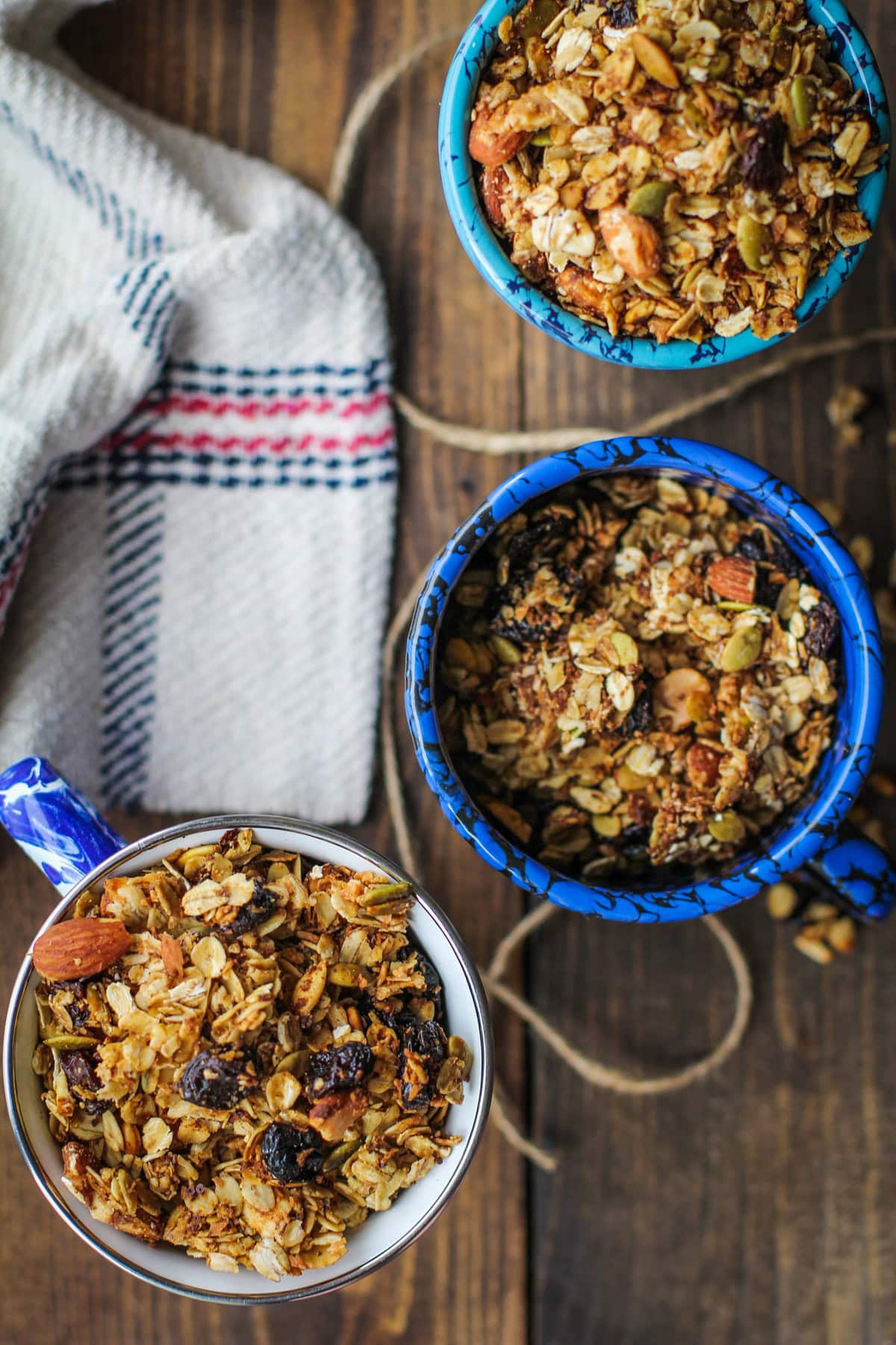 Three mugs full of homemade granola with a napkin to the side.