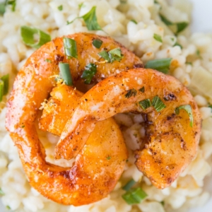 Lemon Garlic shrimp with sear marks on top of risotto sprinkled with green onions.