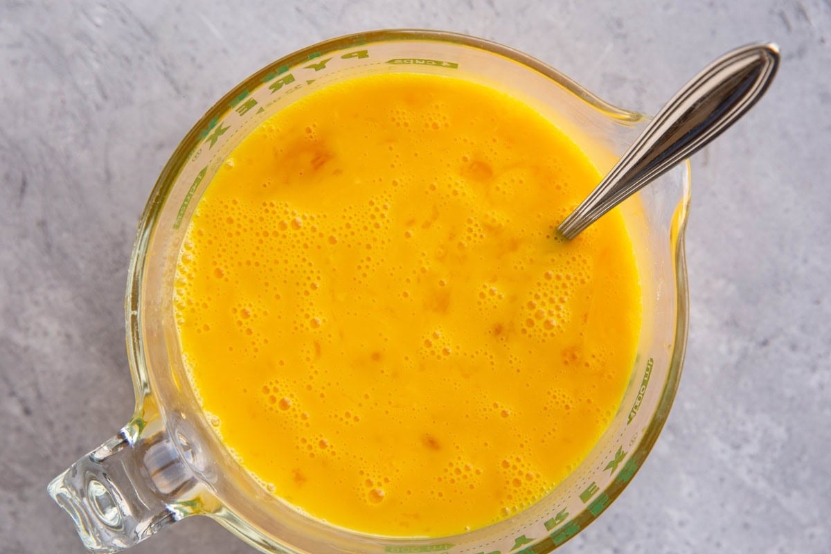 large measuring cup full of beaten eggs.