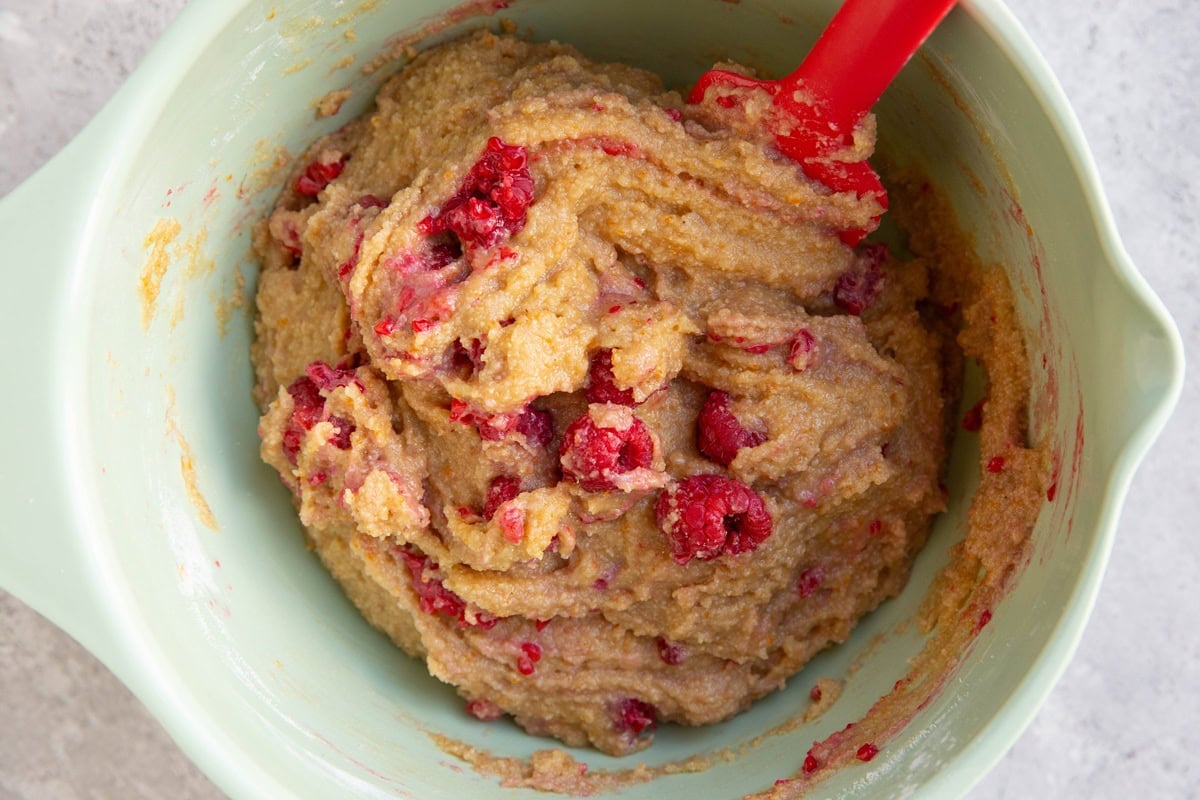Mixing bowl full of raspberry scone dough with raspberries mixed in.