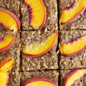 Sliced peach baked oatmeal on a sheet of parchment paper, ready to serve.