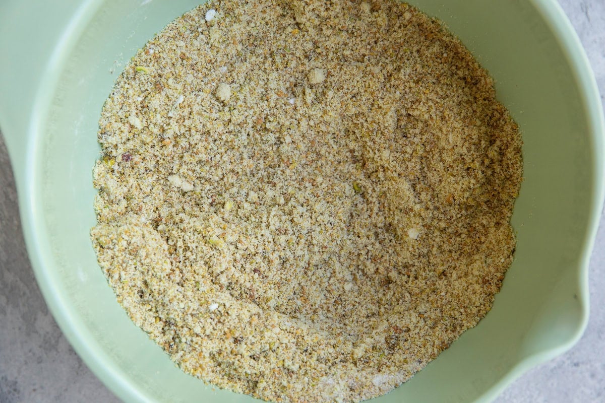 Bowl full of almond and pistachio flours and sugar (dry ingredients) for cake.